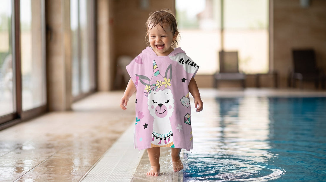 Poncho serviette à capuche enfant motif lama licorne porté au bord de la piscine