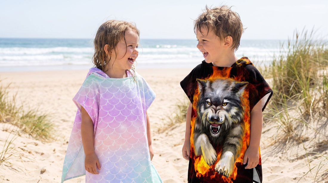 Fille en poncho écailles arc-en-ciel pastel et garçon en poncho loup de feu sur la plage