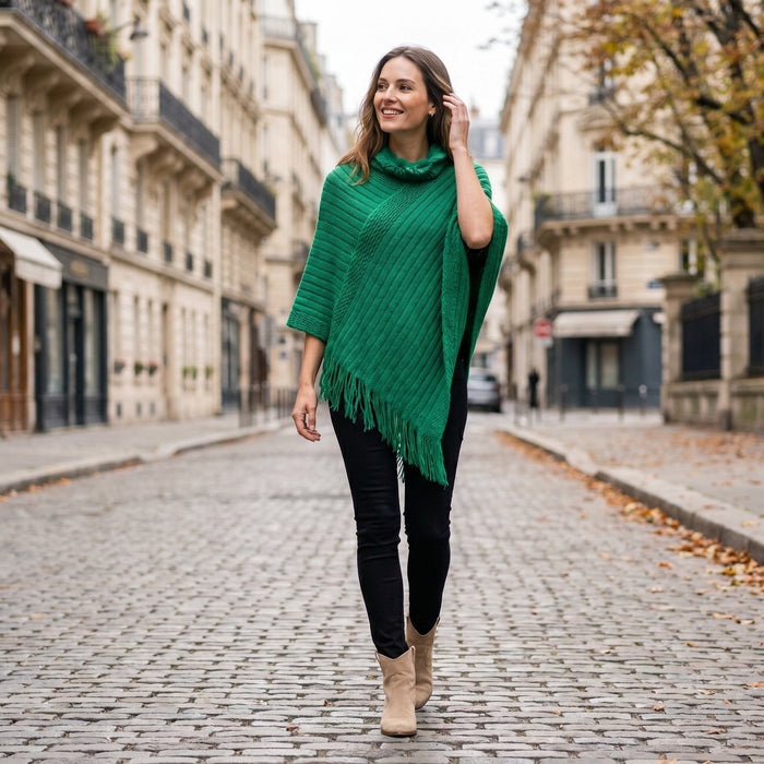 Poncho à capuche femme en maille à franges, coloris vert, porté de face par une femme en extérieur