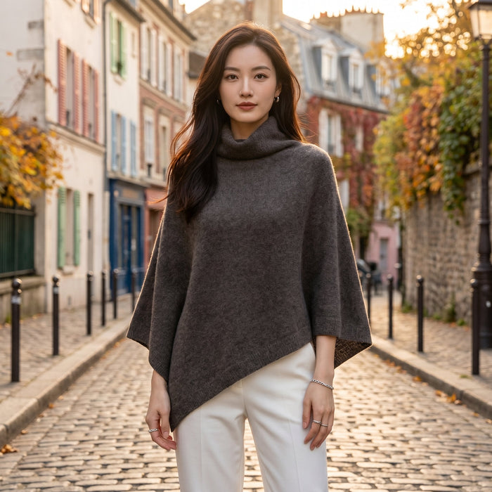 Poncho en laine femme col roulé gris foncé porté par une femme, vue de face en extérieur.