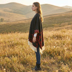 Cape poncho femme ouverte à motif et franges, portée de profil par une femme dans un champ