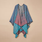 Cape poncho femme ouverte colorblock présentée à plat, montrant ses motifs bleus, roses et turquoises avec bordures grises