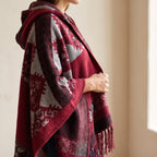 Détail de la maille jacquard et des franges de la cape poncho femme rouge, vue rapprochée de l'épaule