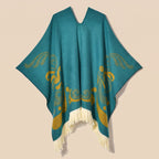 Cape poncho femme ouverte motif turquoise, présentée à plat de face. Le décolleté en V et les motifs dorés sur le devant
