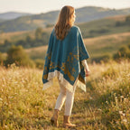 Cape poncho femme ouverte motif turquoise, portée de dos avec une légère torsion du corps. Le motif doré et les franges sont