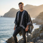 Cape poncho homme ouverte motif bandana noir et blanc, portée par un homme de face en extérieur près de la mer