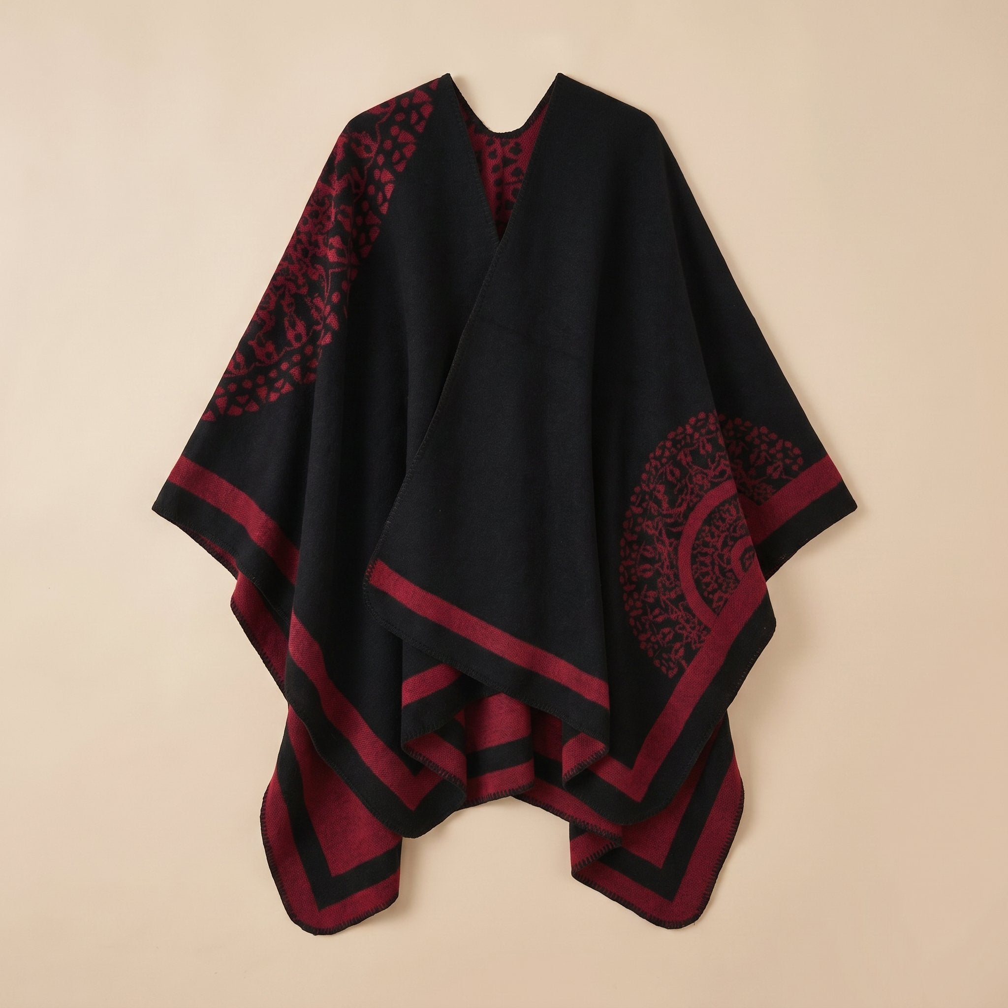 Manteau poncho femme, cape ouverte à bordure noire et bordeaux, avec motifs circulaires et géométriques, posé à plat