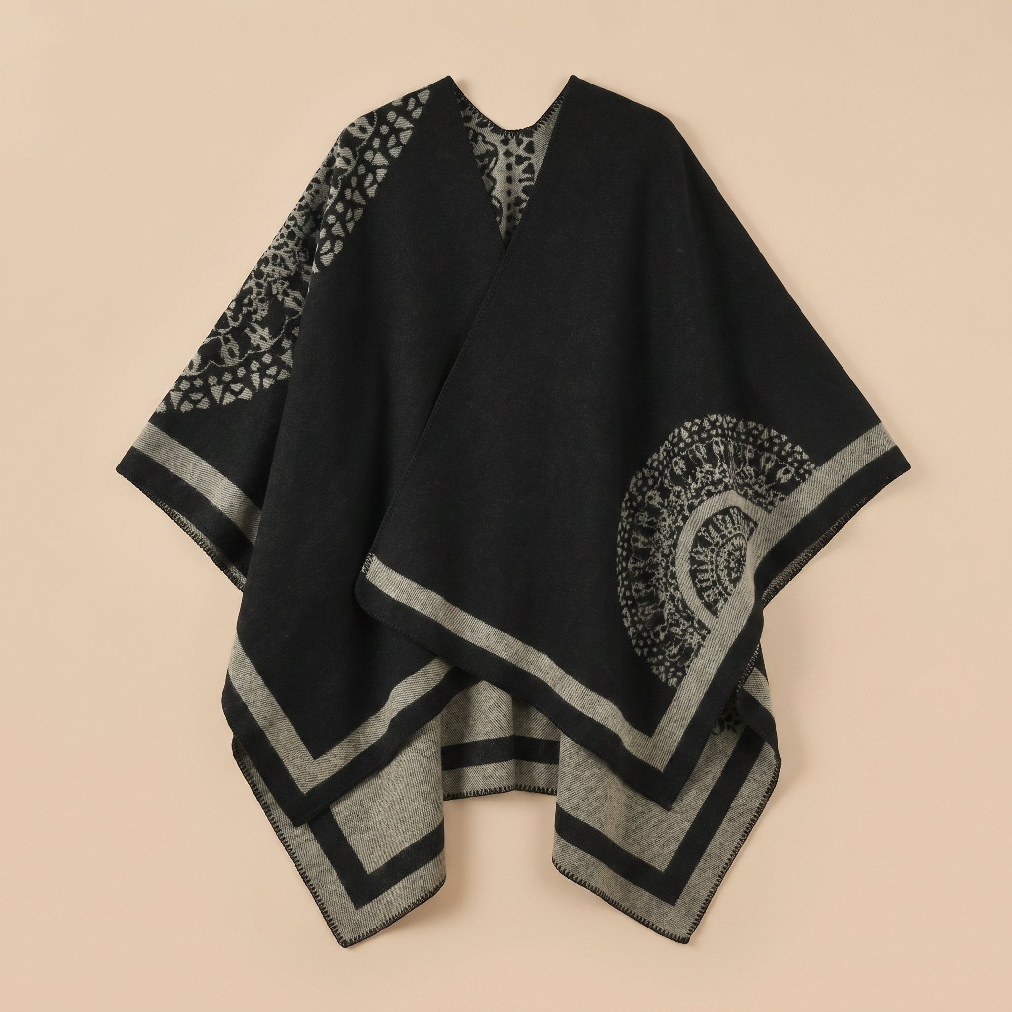 Manteau poncho femme, cape ouverte à bordure noire et gris-beige, avec motifs circulaires et géométriques, posé à plat