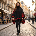 Manteau poncho femme, cape ouverte à bordure noire et rouge, avec motifs, portée par une femme marchant en extérieur