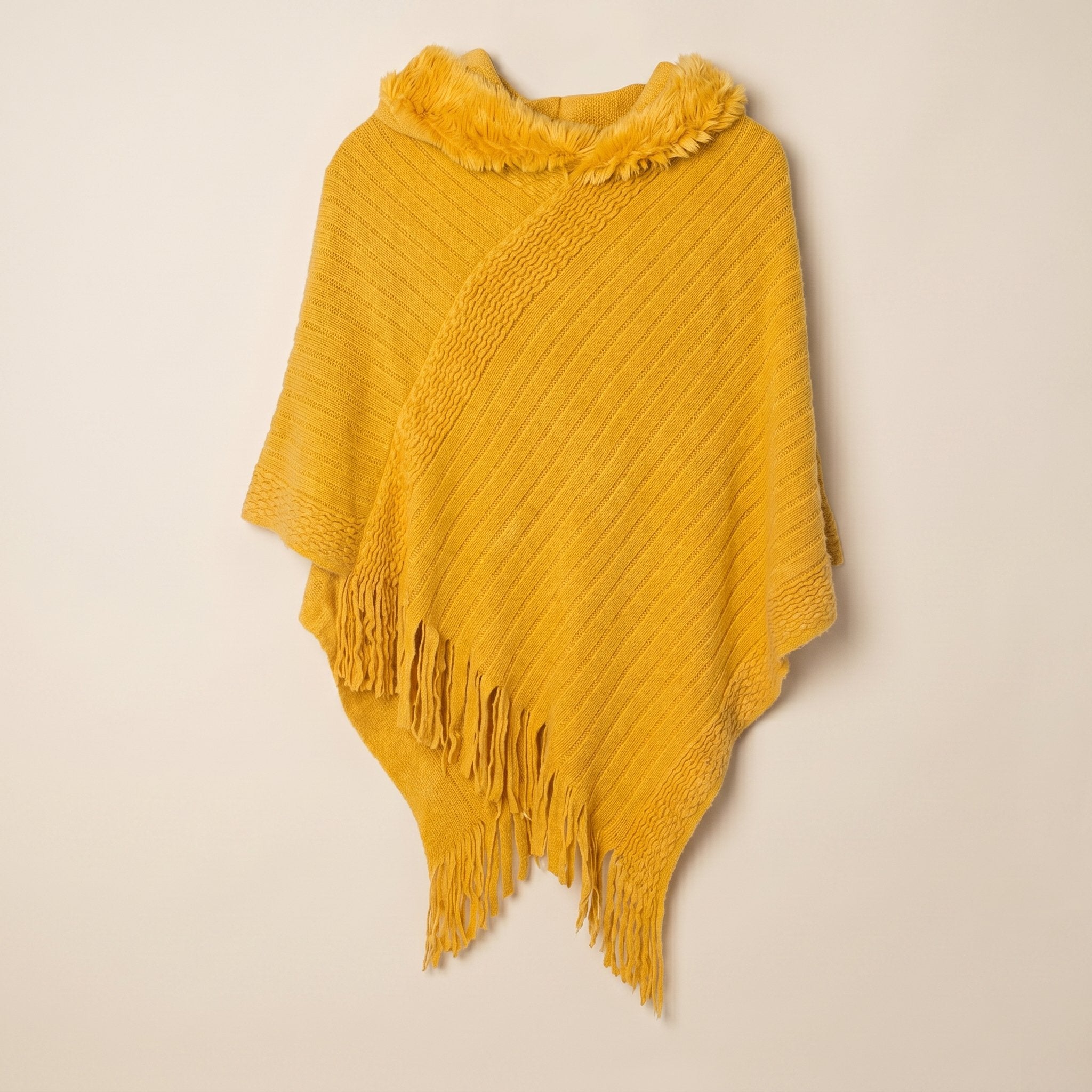Poncho à capuche femme en maille à franges, coloris jaune moutarde, présenté à plat sur fond uni