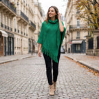 Poncho à capuche femme en maille à franges, coloris vert, porté de face par une femme en extérieur