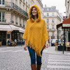 Poncho à capuche femme en maille à franges, coloris jaune, porté par une femme avec la capuche sur la tête