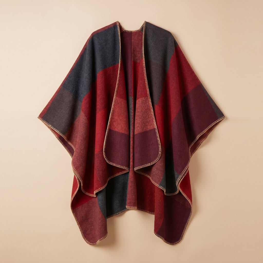 Poncho cape colorblock rouge, présenté à plat sur un fond uni clair, montrant ses motifs.