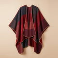 Poncho cape colorblock rouge, présenté à plat sur un fond uni clair, montrant ses motifs.
