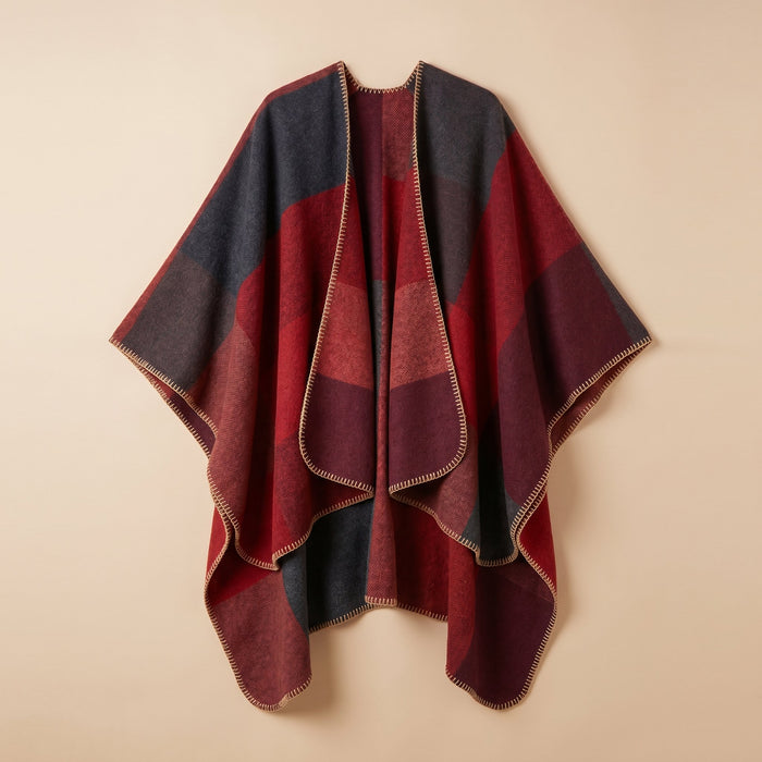 Poncho cape colorblock rouge, présenté à plat sur un fond uni clair, montrant ses motifs.