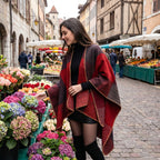 Poncho cape colorblock rouge, porté par une femme souriante regardant des fleurs sur un marché.