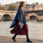 Poncho cape femme bleu jean porté par une femme marchant le long d'une rivière, vue de profil.