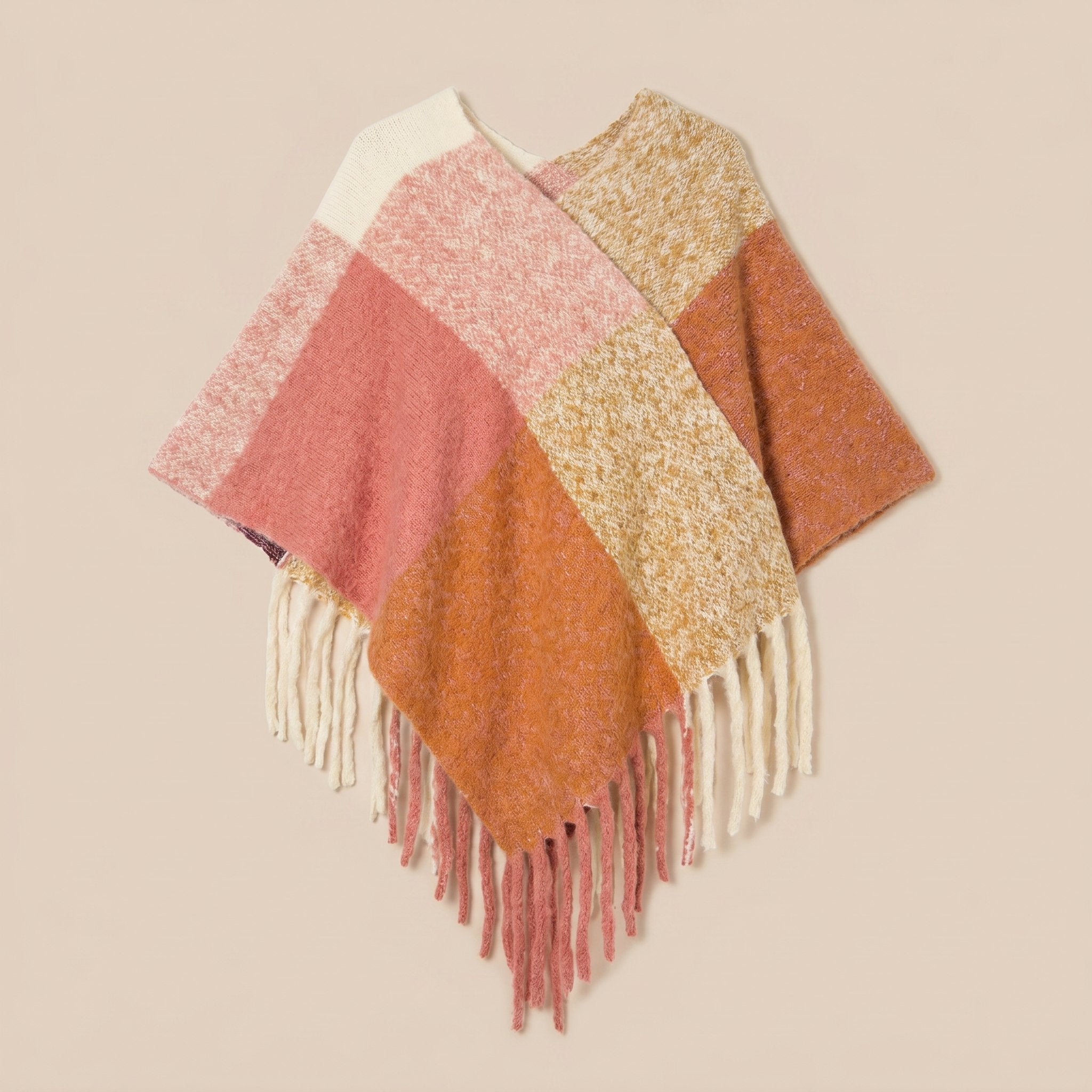Poncho cape femme colorblock corail posé à plat, vue de dessus, avec ses franges claires.