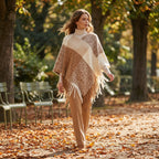 Poncho cape femme colorblock beige et marron porté par une femme marchant dans un parc en automne.