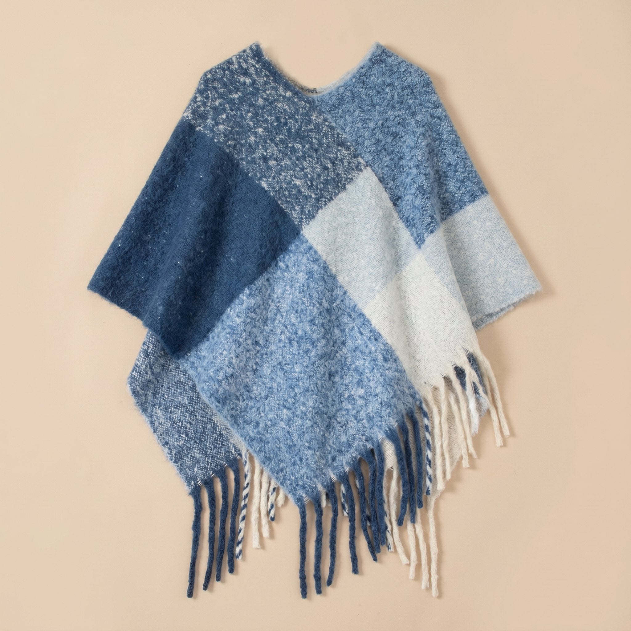 Poncho cape femme colorblock bleu présenté à plat, avec un cadrage large et ses franges.