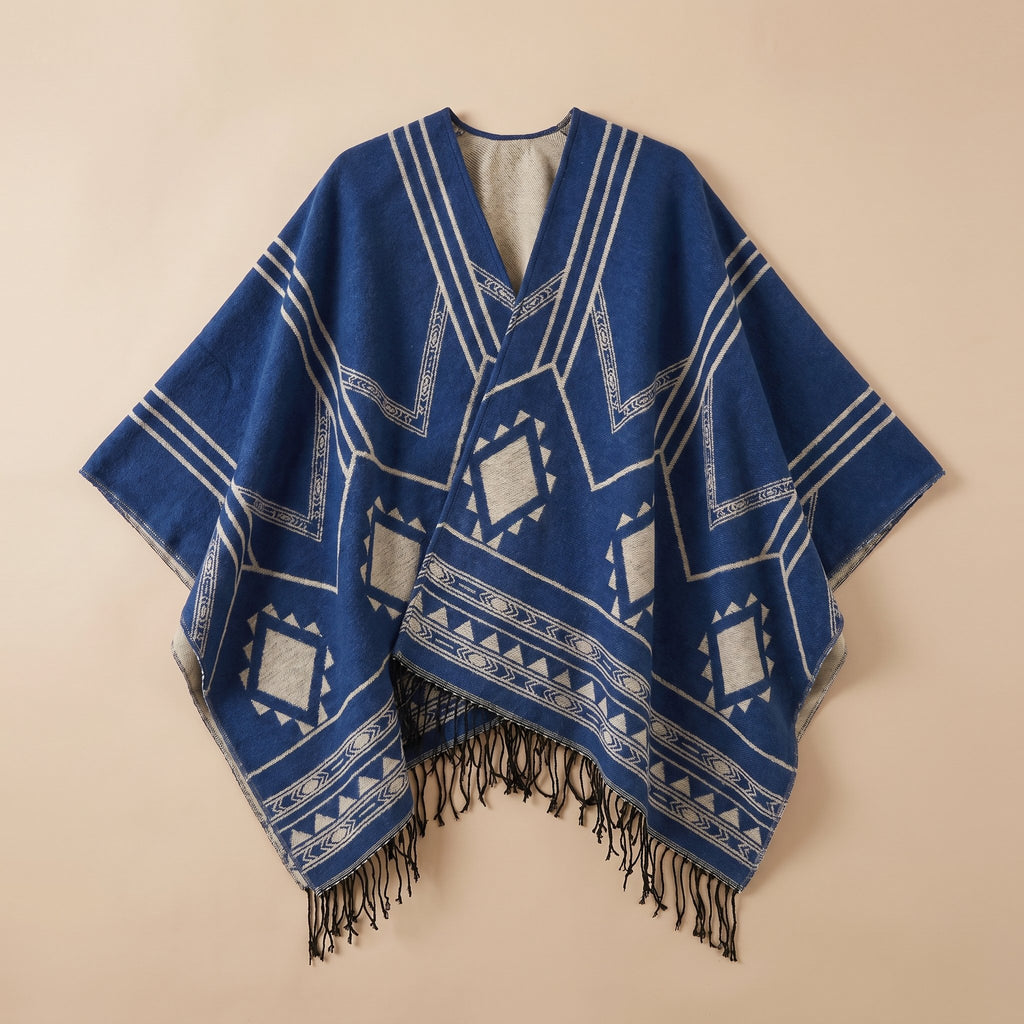 Poncho cape femme à motif géométrique et franges bleu et gris clair, présenté à plat sur un fond uni, vue de face