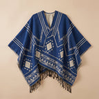 Poncho cape femme à motif géométrique et franges bleu et gris clair, présenté à plat sur un fond uni, vue de face