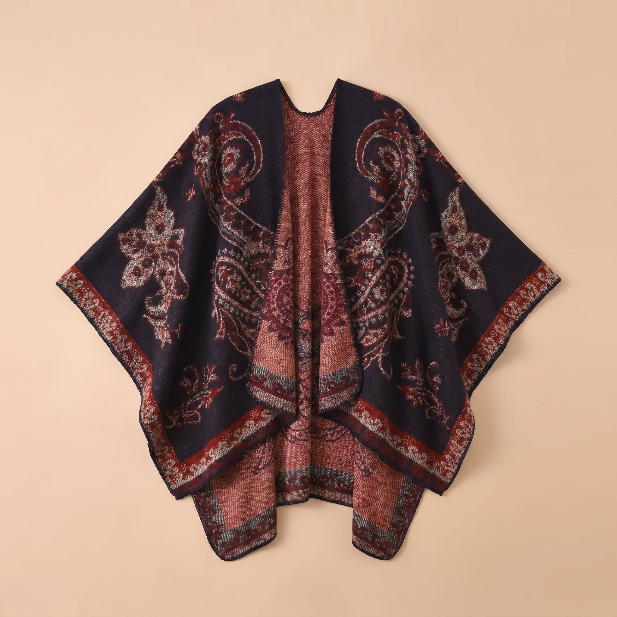 Poncho cape femme motif Paisley bleu marine, vue d'ensemble du vêtement posé à plat sur un fond neutre.