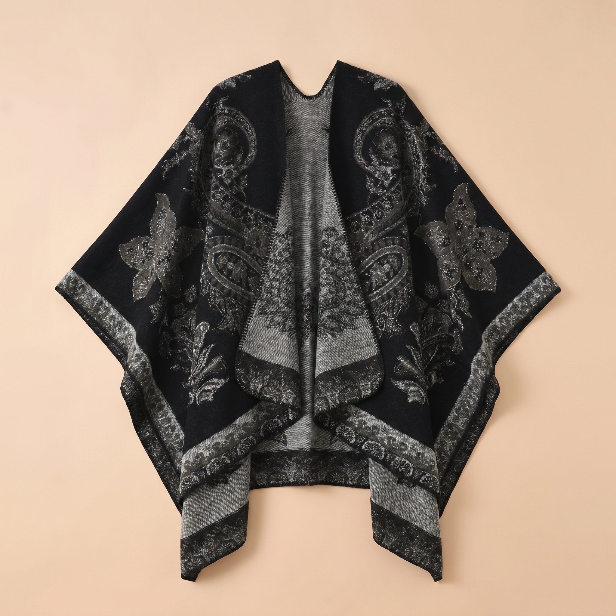 Poncho cape femme motif Paisley noir et gris, déplié, mettant en valeur le contraste des couleurs.