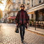Poncho cape femme motif Paisley noir et rouge, porté par une femme marchant vers l'observateur sur une rue pavée.