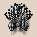 Poncho cape homme à damier noir et blanc, posé à plat de face, montrant les franges blanches