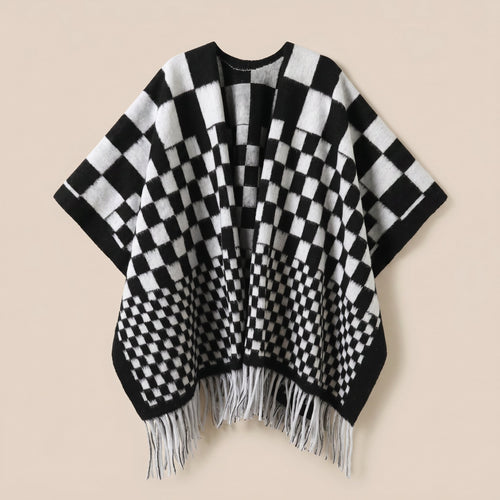 Poncho cape homme à damier noir et blanc, posé à plat de face, montrant les franges blanches