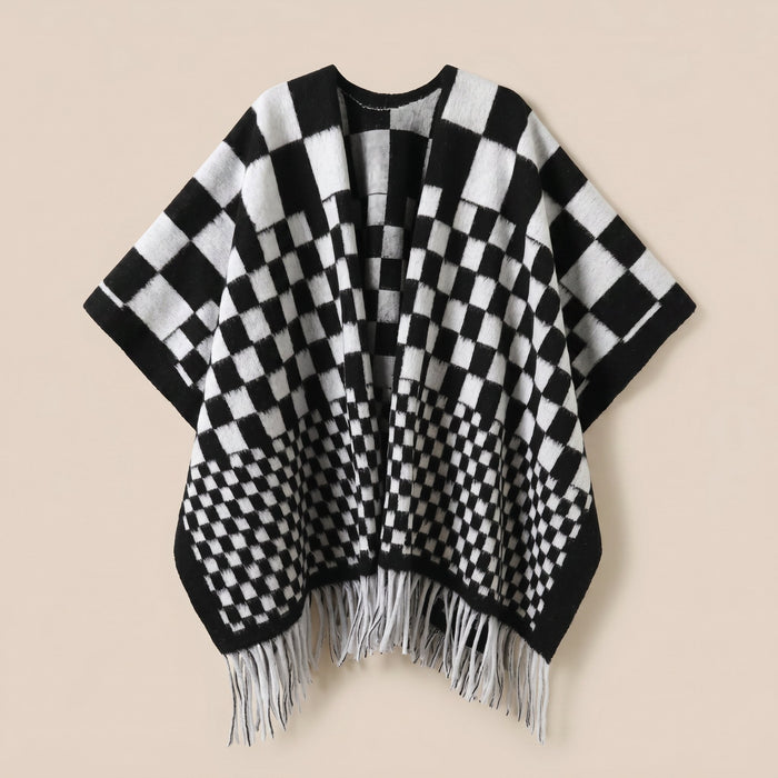 Poncho cape homme à damier noir et blanc, posé à plat de face, montrant les franges blanches
