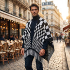 Poncho cape homme à damier noir et blanc, porté de face par un homme devant un café avec terrasse