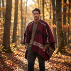 Poncho cape homme ethnique bordeaux, porté par un homme marchant dans une forêt d'automne.