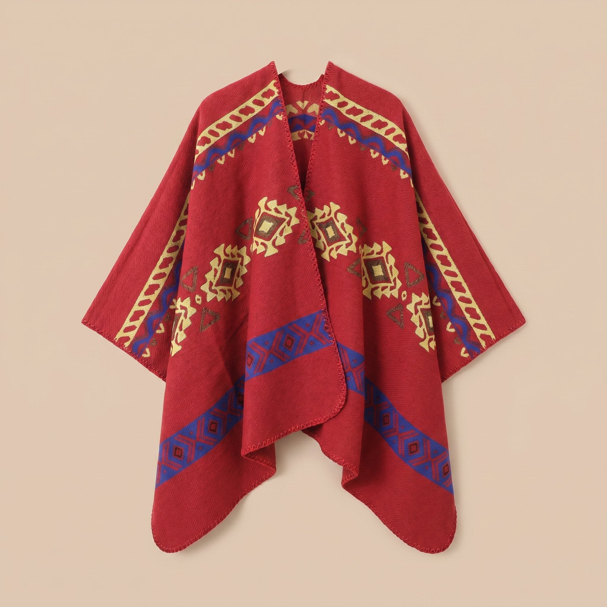 Poncho cape homme ethnique rouge, étalé à plat sur un fond beige clair.