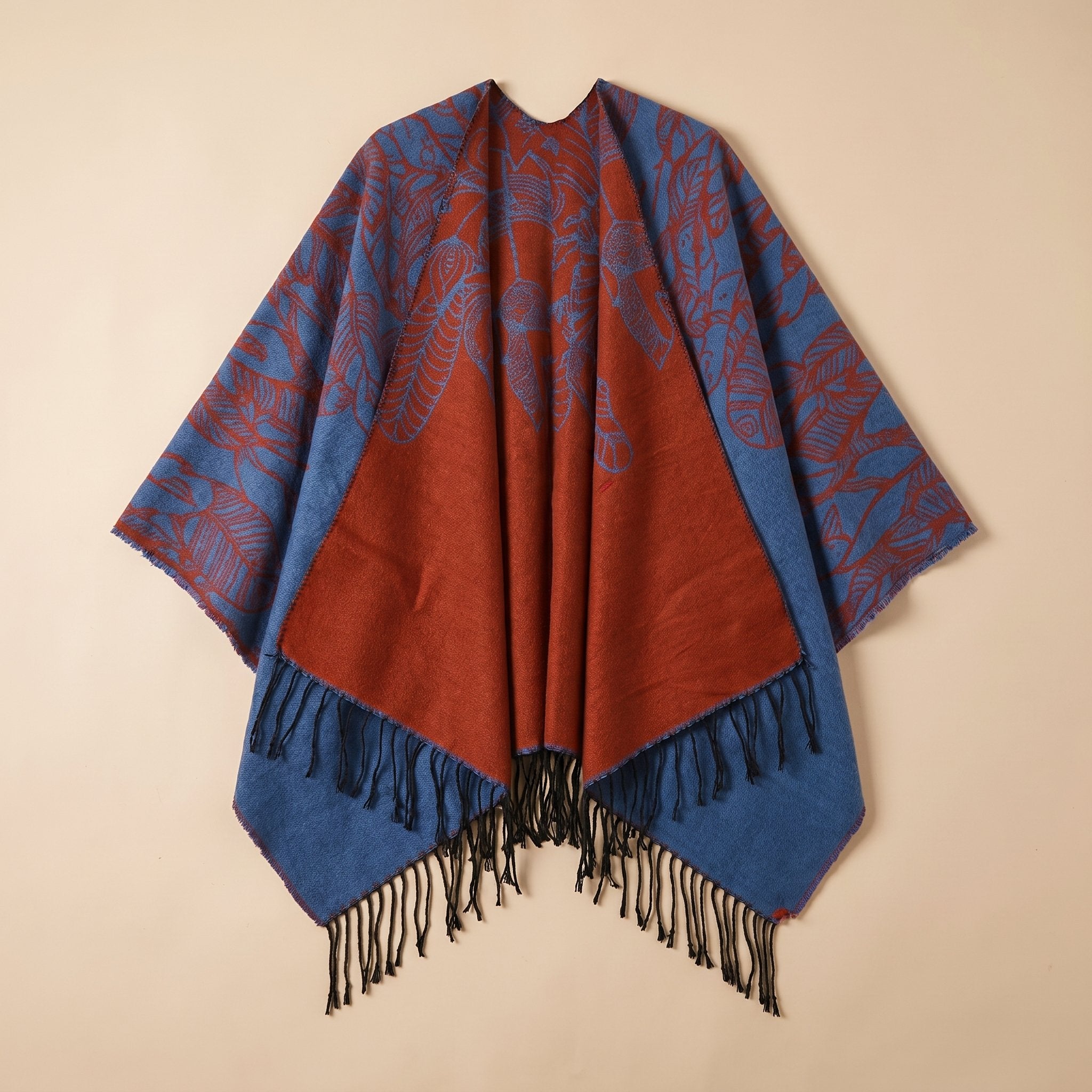 Poncho cape homme à franges rouille et bleu, motifs de plumes, présenté à plat