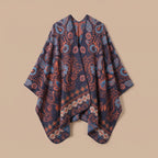Poncho cape homme paisley bleu présenté à plat sur un fond neutre, montrant la coupe ample et le motif détaillé du tissu