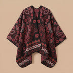 Poncho cape homme paisley bordeaux, posé à plat sur un fond uni, montrant l'ensemble du motif bordeaux et noir
