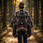 Poncho cape homme motif Paisley crème, porté de dos par un homme s'éloignant dans la forêt.