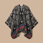 Poncho cape homme paisley noir présenté à plat sur un fond uni