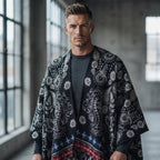Poncho cape homme paisley noir porté de face par un homme, montrant le motif floral et le liseré rouge et bleu