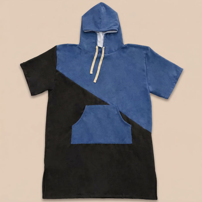 Poncho serviette à capuche bicolore bleu et noir, posé à plat sur un fond uni.