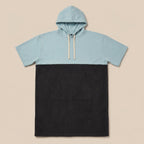 Poncho serviette à capuche bicolore ciel et gris, présenté à plat sur un fond uni clair.