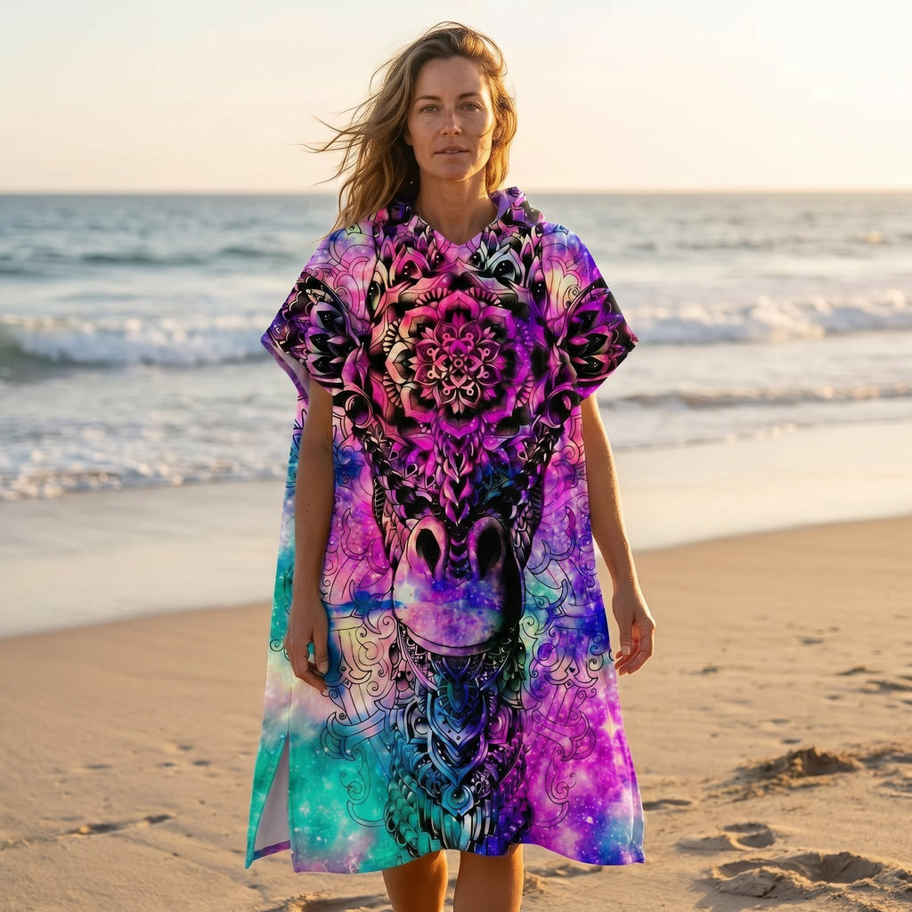 Poncho serviette a capuche motif girafe mandala, porté par une femme sur une plage au coucher du soleil.