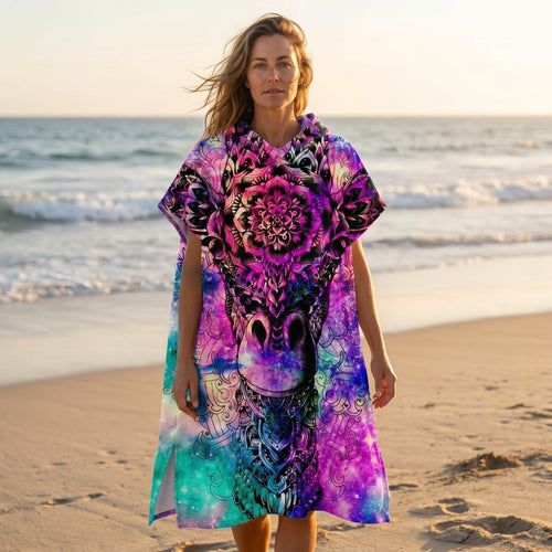 Poncho serviette a capuche motif girafe mandala, porté par une femme sur une plage au coucher du soleil.