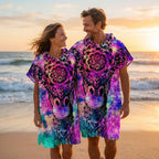 Poncho serviette a capuche motif girafe mandala, porté par un couple souriant marchant sur la plage au crépuscule.