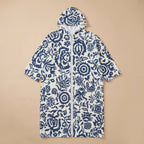 Poncho serviette à capuche motif fleurs bleues, présenté à plat sur un fond uni.