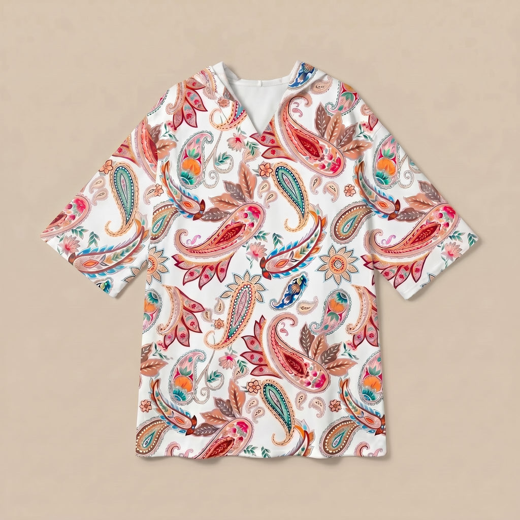 Poncho serviette a capuche motif paisley colore, presente a plat sur fond uni beige.