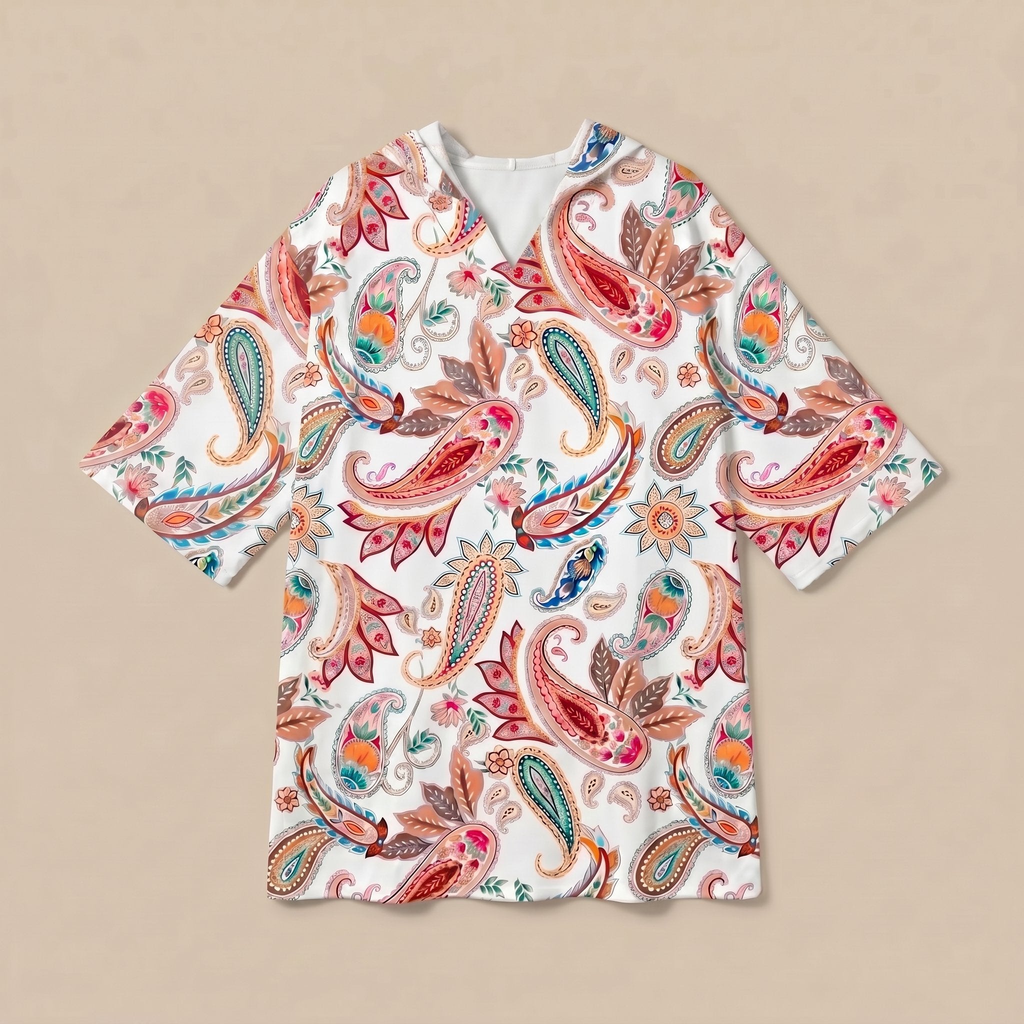 Poncho serviette a capuche motif paisley colore, presente a plat sur fond uni beige.