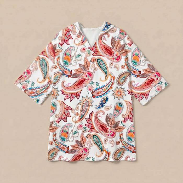 Poncho serviette a capuche motif paisley colore, presente a plat sur fond uni beige.